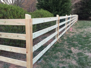 A newly built wooden fence in a grassy area.