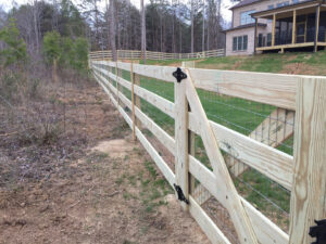 Newly built wooden fence along a yard near a house.