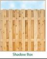A wooden fence with vertical slats under a blue sky.