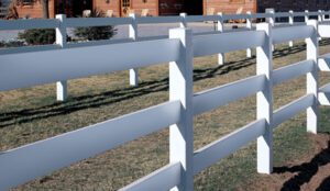 White wooden fence panels lined up outdoors on grass.
