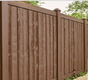 Tall brown wooden fence panels with posts in a backyard.